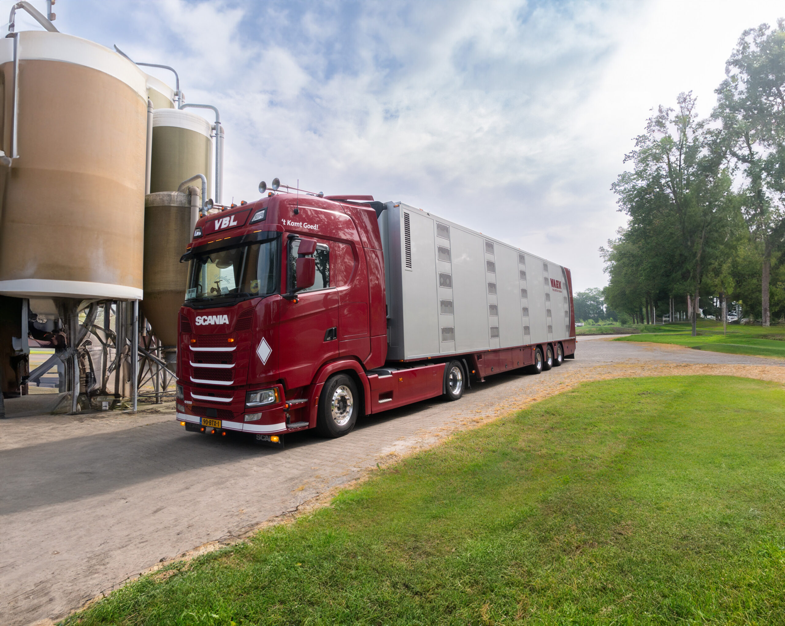 VBL veetransport voertuig met VAEX oplegger, geparkeerd bij stal